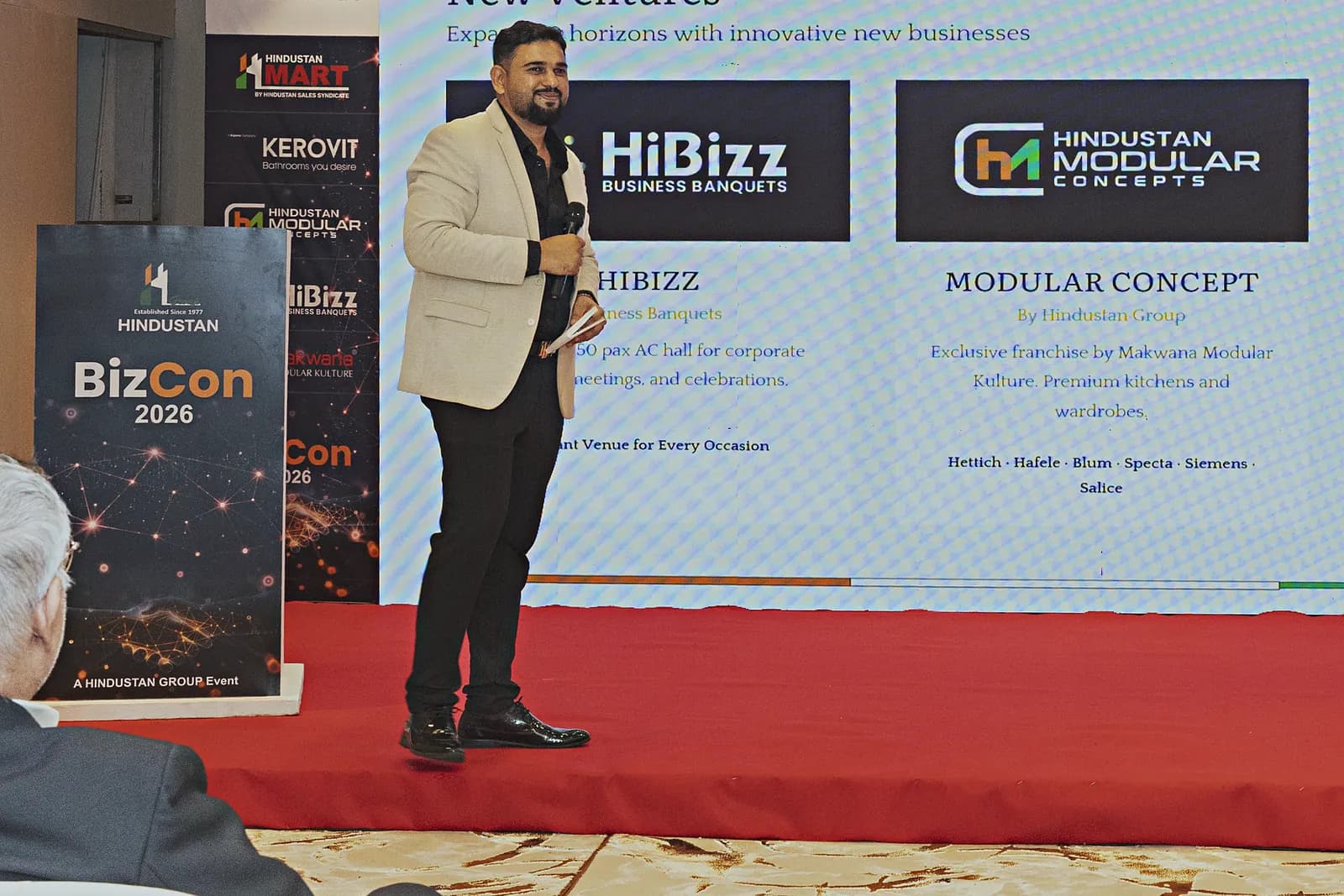 A new venture announced on the presentation screen beside the speaker at HiBizz, Goa